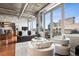 Inviting living area with floor-to-ceiling windows, concrete ceilings and hardwood floors, ideal for modern living at 1401 Wewatta St # 911, Denver, CO 80202