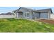 View of the green backyard featuring a lawn, new construction home and a white fence at 523 Beckwourth Ave, Fort Lupton, CO 80621