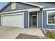 Close-up of the home's garage, entrance, and stone landscaping at 523 Beckwourth Ave, Fort Lupton, CO 80621