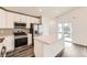 Bright kitchen features white cabinets, stainless appliances, and an island with a stone countertop at 523 Beckwourth Ave, Fort Lupton, CO 80621