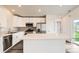 Bright kitchen features white cabinets, stainless appliances, and an island with a stone countertop at 523 Beckwourth Ave, Fort Lupton, CO 80621