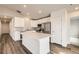 Bright kitchen features white cabinets, stainless appliances, and an island with a stone countertop at 523 Beckwourth Ave, Fort Lupton, CO 80621