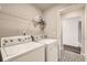 Bright laundry room with a washer, dryer, storage shelf and a patterned tile floor at 523 Beckwourth Ave, Fort Lupton, CO 80621