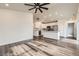 Spacious living area with wood floors and a view of the kitchen with stone countertop island at 523 Beckwourth Ave, Fort Lupton, CO 80621