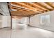 Unfinished basement with painted floors, exposed ceiling and support beams, and natural light at 741 Hallmark Ln, Longmont, CO 80504