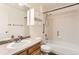 Well-lit bathroom features a shower and tub, a wood vanity, and functional storage shelves at 741 Hallmark Ln, Longmont, CO 80504