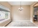 The dining room is carpeted and features a chandelier and large window at 741 Hallmark Ln, Longmont, CO 80504