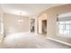 Spacious living room featuring carpet, large windows, and arched entryways at 741 Hallmark Ln, Longmont, CO 80504