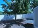 Backyard features a white privacy fence, a tree that offers shade and a wood area on the left at 9669 W Chatfield Ave # A, Littleton, CO 80128