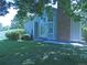 Charming home exterior with a brick chimney, complemented by a lush green lawn and mature tree at 9669 W Chatfield Ave # A, Littleton, CO 80128