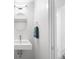 Clean and minimalist bathroom features a modern sink, oval mirror, and towel rack next to a door at 1581 King St, Denver, CO 80204