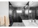 Modern bathroom with black marble tile, glass shower, and white vanity at 1581 King St, Denver, CO 80204