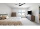 Calm bedroom with ceiling fan, large window and TV above a dresser and a neutral comforter at 1581 King St, Denver, CO 80204