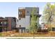 Modern three-story home with wood and grey paneled design and wood fence at 1581 King St, Denver, CO 80204