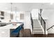 Modern kitchen featuring an island with seating and pendant lighting, and a staircase with black railings at 1581 King St, Denver, CO 80204