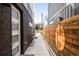 Side yard entrance showcases modern design between buildings with wood fence at 1581 King St, Denver, CO 80204