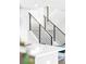 A modern staircase with black metal railings rises next to a white countertop and stylish blue chairs at 1581 King St, Denver, CO 80204