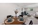 Cozy dining area with a wooden table set for four and light-filled living space in the background at 16359 W 10Th Ave # T1, Golden, CO 80401