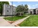 Apartment building featuring lush landscaping, mature trees, and well-maintained lawn at 16359 W 10Th Ave # T1, Golden, CO 80401