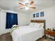 Bright bedroom with white walls, ceiling fan, decorative wall art, and a comfortable bed with crisp white linens at 2433 E 90Th Ave, Thornton, CO 80229