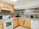 Well-equipped kitchen featuring white appliances, wooden cabinets, and tiled backsplash, blending style and functionality at 2433 E 90Th Ave, Thornton, CO 80229