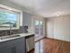 Updated kitchen with stainless steel appliances, gray cabinets, and tile backsplash overlooks the outdoor deck at 2433 E 90Th Ave, Thornton, CO 80229