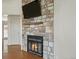Cozy living room with a striking stone fireplace, hardwood floors, and a mounted television at 2433 E 90Th Ave, Thornton, CO 80229