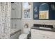 Stylish bathroom with subway tile shower, stained glass window and dark blue accent wall at 2445 N Franklin St, Denver, CO 80205