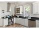 Charming kitchen with white cabinets, black countertops and stainless steel appliances providing a clean, modern look at 2445 N Franklin St, Denver, CO 80205