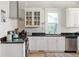 Well-lit kitchen featuring white cabinets, black countertops, a stainless steel dishwasher, and a gas range at 2445 N Franklin St, Denver, CO 80205