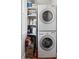 Convenient laundry area features a stacked washer and dryer, plus organized shelving for supplies at 2445 N Franklin St, Denver, CO 80205