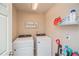 Laundry room with modern washer and dryer and storage shelf, creating a functional space at 9675 E 105Th Ave, Commerce City, CO 80640