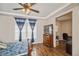Bedroom with tray ceilings, a ceiling fan, lots of natural light, hardwood floors, and an open office area at 9675 E 105Th Ave, Commerce City, CO 80640