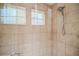 Walk in shower featuring tiled walls, a shower head, a handheld sprayer and two windows for natural light at 9675 E 105Th Ave, Commerce City, CO 80640