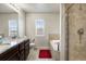 Bathroom featuring double sinks, granite countertops, a soaking tub, and a tiled shower at 9225 Rockhurst St # A, Highlands Ranch, CO 80129