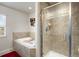 Bright bathroom with a bathtub, a tiled glass door shower, and a window for natural light at 9225 Rockhurst St # A, Highlands Ranch, CO 80129