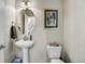 Elegant powder room featuring pedestal sink, oval mirror, and stylish decor at 9225 Rockhurst St # A, Highlands Ranch, CO 80129