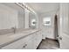 Bright bathroom featuring a double vanity, modern fixtures, and a shower-tub combo for a spa-like experience at 17280 W 70Th Ave, Arvada, CO 80007