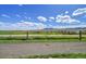 Scenic view of rolling green fields with a mountain range in the distance under a blue sky with puffy clouds at 17280 W 70Th Ave, Arvada, CO 80007