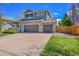 Two-story home showcasing a three-car garage and landscaped front yard at 17280 W 70Th Ave, Arvada, CO 80007