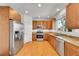 Cozy kitchen featuring stainless steel appliances, granite countertops, and natural wood cabinets at 17280 W 70Th Ave, Arvada, CO 80007