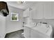 Functional laundry room with white cabinetry, washer, dryer and a window for natural light at 17280 W 70Th Ave, Arvada, CO 80007