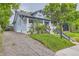 Light blue house with a gravel driveway, green lawn, and a view of the well-maintained exterior at 3396 S Logan St, Englewood, CO 80113