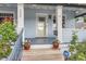 Inviting front porch with white columns, potted plants, and a view of the home's entrance at 3396 S Logan St, Englewood, CO 80113