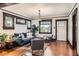Elegant living room with hardwood floors, dark wood trim, a plush blue sofa, and ample natural light at 3396 S Logan St, Englewood, CO 80113