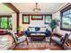 Bright living room with hardwood floors, dark wood trim, a plush blue sofa, decorative rug and large windows at 3396 S Logan St, Englewood, CO 80113