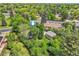 An aerial view shows the house and yard, with mature trees providing privacy at 8600 W 2Nd Ave, Lakewood, CO 80226