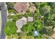 This aerial shot showcases the property's roof, driveway, and the mature trees surrounding it at 8600 W 2Nd Ave, Lakewood, CO 80226