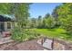 Serene backyard featuring lush landscaping, mature trees, and charming water feature at 8600 W 2Nd Ave, Lakewood, CO 80226