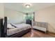 Comfortable bedroom featuring wood floors, natural light, a bed, and a crib at 8600 W 2Nd Ave, Lakewood, CO 80226